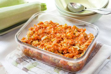 Squash stew with carrot and tomatoes in a square glass dish