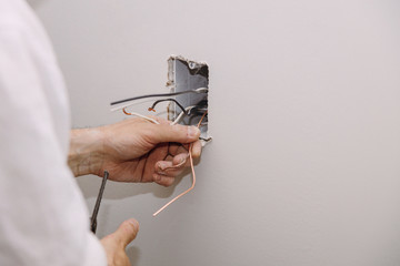 Unfinished electrical mains outlet socket with electrical wires and connector installed in...