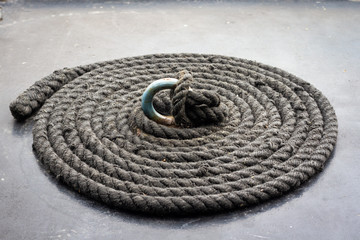 Fototapeta na wymiar Coiled weathered black boat rope