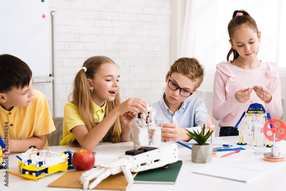 Poster Excited children programming robots together at stem class