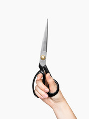 female hand holding old tailor scissors on a gray isolated background