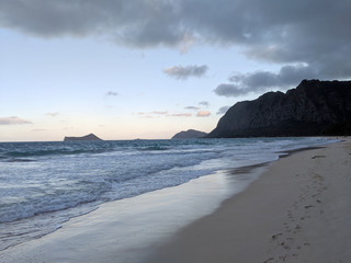 Gentle wave lap on Waimanalo Beach looking towards Rabbit island and Rock island at dusk