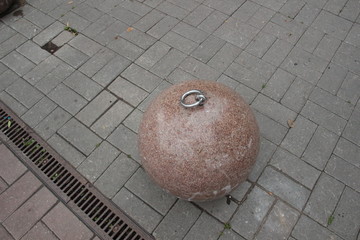 Rose marble round street decoration with metal ring on pavement