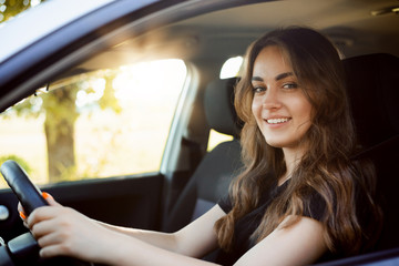 Happy female student driving car just after receiving car license, happy to pass driving exam and drive car by herself