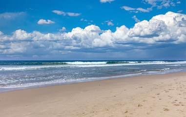 Sandy beach empty. Blue sky with clouds, blue sea