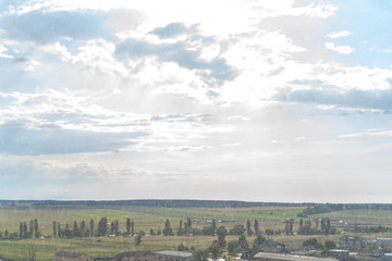 Aerial view of rural landscape near the city during rain in sunny cloudy weather
