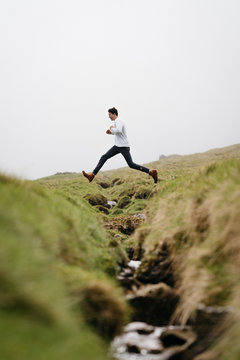 Man Jumping Over Creek