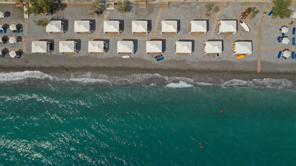 Aerial drone top view photo of beautiful organised Mediterranean sandy beach with crystal clear turquoise sea