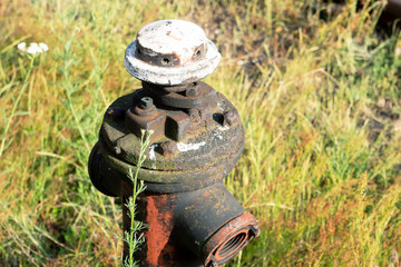 Stryi hydrant overgrown with grass. Water pipe for refueling the fire truck