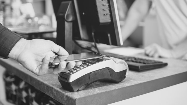 Shopper does payment using smartphone. NFC technology