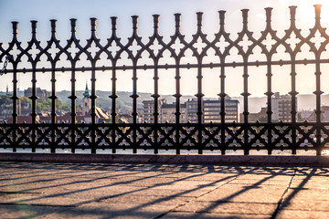Sunset. Reflection of the lattice fencing. Danube Embankment in Budapest