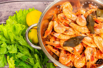 Cooked Atlantic prawns flow around in a stainless steel colander