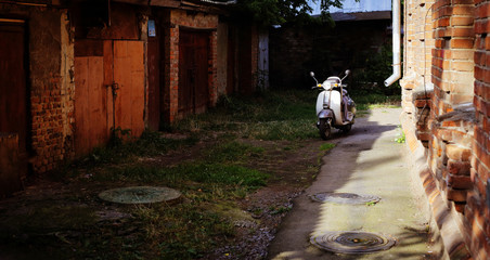 Fototapeta na wymiar Retro transport - scooter among ruins of buildings