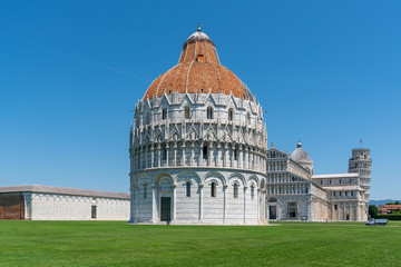 the Leaning Tower of Pisa and the Cathedral of Pisa in front of a bright blue sky