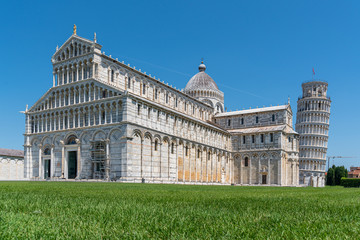 Fototapeta na wymiar the Leaning Tower of Pisa and the Cathedral of Pisa in front of a bright blue sky