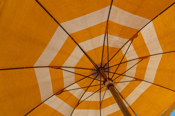 a bright yellow parasol stretched out on the beach