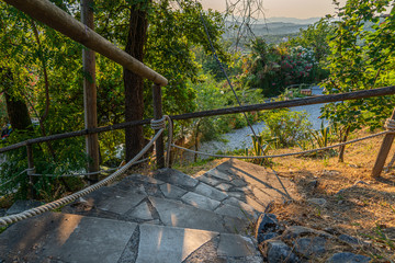 a Tuscan landscape in the background and a stone staircase in the foreground
