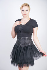 Portrait of beautiful girl in black corset goth dress on white isolated studio background
