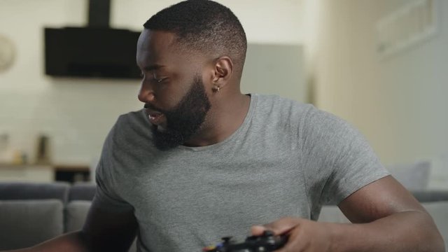 Young man playing video game at home. Nervous guy holding play station.