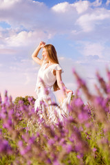 Fototapeta na wymiar beautiful woman looking ahead into purple lavender fields during a summer sunset - Image