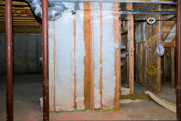 Interior wall framing with piping and wiring installed in the basement of house under remodeling
