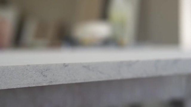 Stone tabletop close-up, on the background is blurred the process of processing hands high-quality granite countertops on the production worker