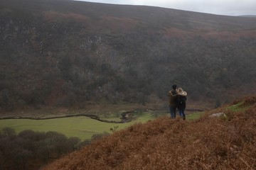 Fototapeta na wymiar Couple looking at a green scenery in Ireland