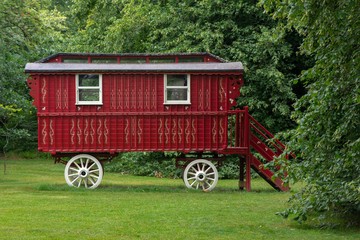 Red vintage circus wagon in green scenery
