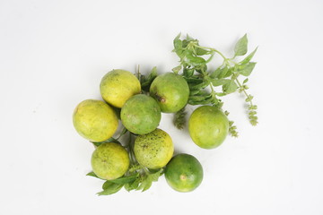 green lemon with leaves on white background