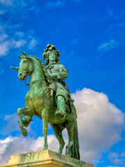 Obraz premium Versailles, France - April 24, 2019: Louis XIV statue just outside of the gates of Versailles Palace on a sunny day outside of Paris, France.
