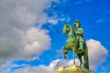 Obraz premium Versailles, France - April 24, 2019: Louis XIV statue just outside of the gates of Versailles Palace on a sunny day outside of Paris, France.