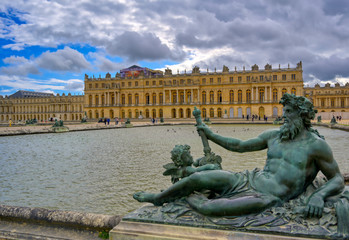 Fototapeta na wymiar Versailles, France - April 24, 2019: The statues and fountains in and around the garden of Versailles Palace on a sunny day outside of Paris, France.