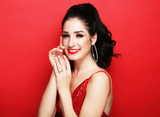 lifestyle, party and people concept - luxury woman in evening dress posing over red background