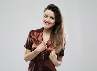 beautiful young girl dressed in pajamas over white background
