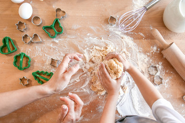 Fototapeta premium Mother with daughter preparing cookies at table