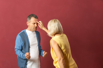 Obraz premium Quarrelling middle-aged couple on color background