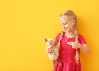 Little deaf mute girl using sign language on color background