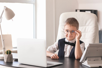 Cute little businessman in office