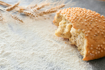 Wheat flour with piece of bread on table