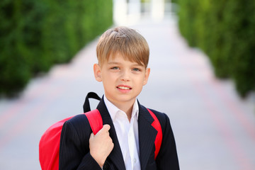 Cute little pupil after classes outdoors