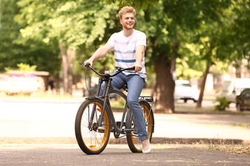 Young man riding bicycle outdoors