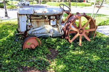 Fototapeta na wymiar Rusty old vintage tractor covered in vines