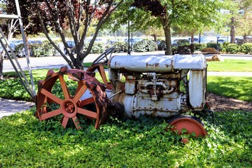 Fototapeta na wymiar Rusty old vintage tractor covered in vines