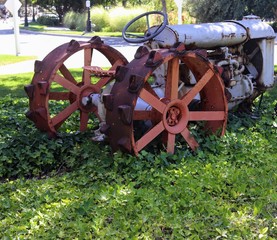 Rusty old vintage tractor covered in vines