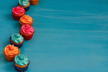 the Colorful homemade cupcakes on a blue background