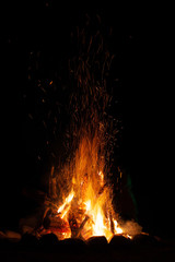 A campfire with sparks at night. © xpabli