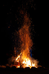 A campfire with sparks at night.