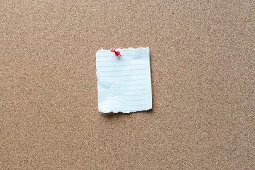 note paper with tack on a cork bulletin board