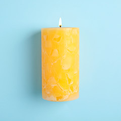 Alight scented wax candle on color background