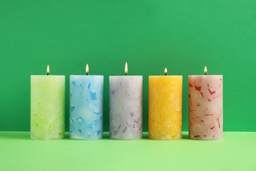 Alight scented wax candles on color background